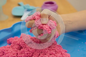 Creative play for children. Education and parenting. Children playing with pink kinetik sand