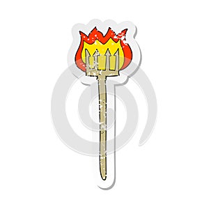 A creative retro distressed sticker of a cartoon flaming devil fork