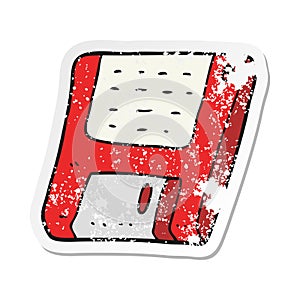 A creative retro distressed sticker of a cartoon old computer disk