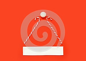 Creative of Santa Claus hat, Christmas holiday minimal concept. Candy canes, white pompom and fur trim on red background