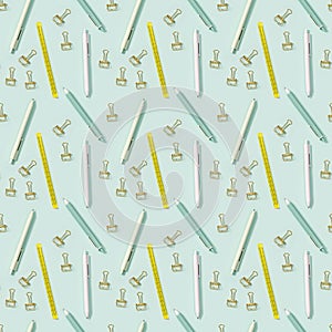 Creative seamless pattern with office supplies, white and green colored pens, yellow ruler and metal paper clips