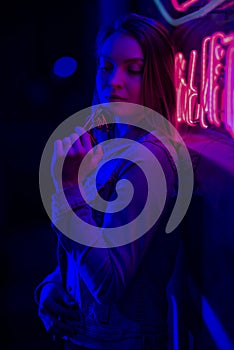 Creative sexual portrait of a girl in neon lighting with glasses, night party, dancing, game business, striptease