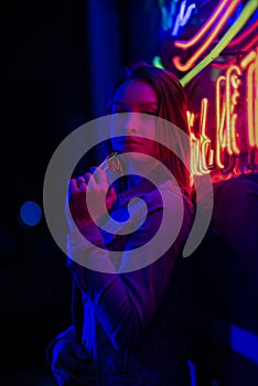 Creative sexual portrait of a girl in neon lighting with glasses, night party, dancing, game business, striptease