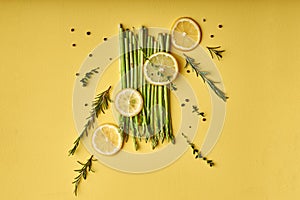 creative shot of Asparagus. asparagus close-up with slice of lemon isolated on yellow