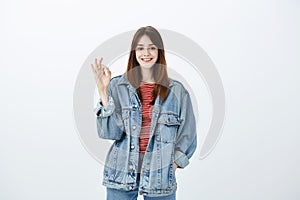 Creative smart girl showing she can deal with anything. Portrait of happy carefree confident woman in stylish denim