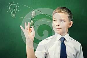 Creative and smart schoolboy has an idea at blackboard