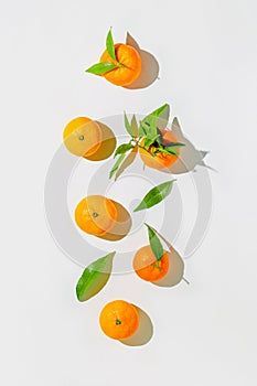 Creative still life composition made of fresh orange tangerins on white background with shadow. Minimal style. Healthy food