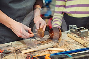 Creative student doing his project in workshop. Boy in the workshop makes crafts with coconut. School, development and learning