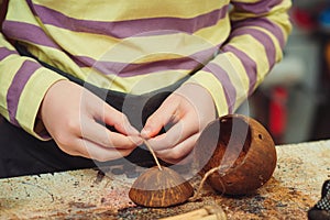 Creative student doing his project in workshop. Boy in the workshop makes crafts with coconut. School, development and learning