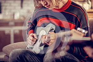 Creative student holding his guitar and composing melody