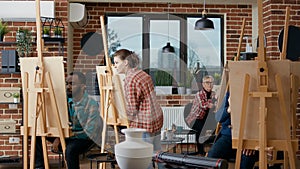 Creative students drawing on canvas in art class workshop