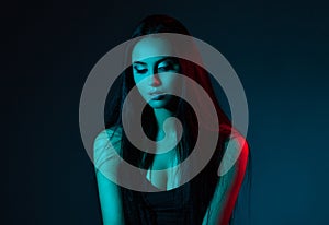 Creative Studio portrait of beautiful female model close-up. The blue lights.