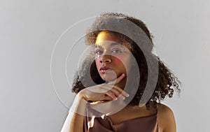 Creative studio portrait of young curly african american model with bright pink color smear on face