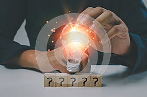 Creative success idea inspiration business concept innovation solution On the desk is a hand holding a light bulb and a wood cube
