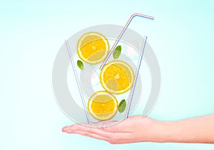 Creative summer cocktail concept. Glass of lemonade made of straws, orange slices, fresh mint leaves and ice cubes