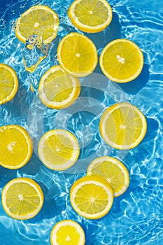 Creative summer composition made of sliced citrus in transparent pool water. Refreshment concept. Healthy refreshing drink theme.