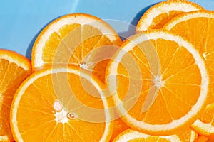 Creative summer composition made of sliced orange closeup on blue background. Freshness concept. Healthy food and vitamin theme.