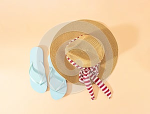 Creative Summer concept of flip flops and straw hat on the sand on the shore. The baackground of travel photo