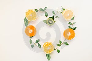 Creative summer healthy food concept idea heart symbol border flame made of citrus fruits lemon , orange and kiwi with green leave