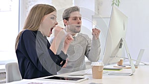 Creative Team Celebrating Success on Desktop in Modern Office