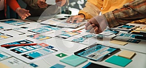 Creative team collaborating on mobile app design concepts with wireframes, sticky notes, and digital tools on a modern