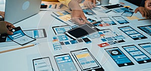 Creative Team Collaborating on Mobile App Design Prototype with Various Wireframes and Layouts for User Interface