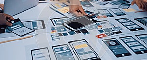 Creative Team Collaborating on Mobile App Design Prototype with Various Wireframes and Layouts for User Interface