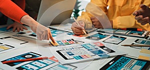 Creative Team Collaborating on Mobile App Design and User Interface Layout with Colorful Wireframes and Prototypes on