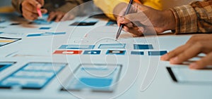 Creative Team Collaborating on User Interface Design and Planning Using Wireframes and Prototypes on a Workspace Table