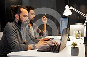 Creative team with computer working late at office
