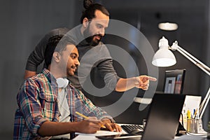 Creative team with computer working late at office