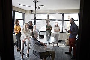 Creative team in a meeting room listening to their manager before a business brainstorm