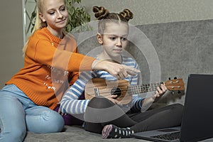 Creative teenagers friends with musical instruments, acoustic guitar and ukulele