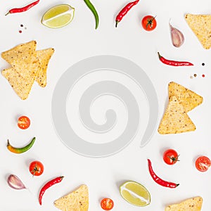 Creative Top view flat lay of fresh mexican food ingredients with tortilla nachos chips garlic pepper lime tomatoes on white table