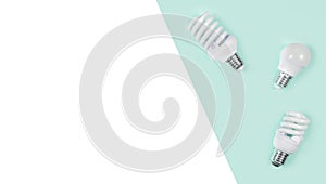 Creative top view flat lay of LED light bulbs mockup composition with copy space on green and white background minimal style.