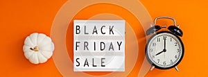 Creative Top view flat lay promotion composition Black friday sale text lightbox alarm clock orange background copy space Template