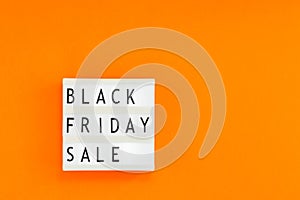 Creative Top view flat lay promotion composition Black friday sale text on white lightbox orange background copy space Template