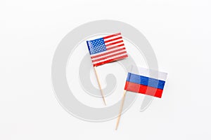 Creative top view flat lay of USA and Russia flags, mockup and copy space on white background in minimal style. Concept of