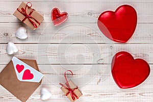 Creative valentine`s day composition, white wooden background with gifts, red hearts, candle, envelope, valentines day concept,