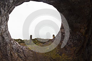 Creative View from within a discarded boiler drum looking out of a vent-like hole on to the unused Porth Wen Brickworks site