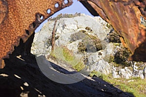 Creative view looking through an opening in a discarded boiler drum on the now unused site of the Porth Wen Brickworks
