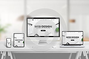 Creative web design studio desk with different devices and responsive web page concept on device screens