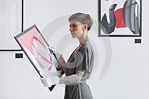 Creative Woman Holding Painting in Art Gallery