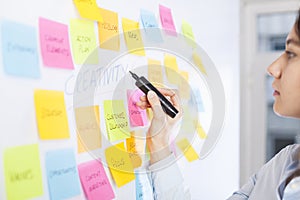 Creative woman use post-it notes to share idea