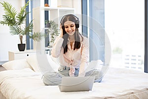 Creative woman working remotely from home listening favorite music.