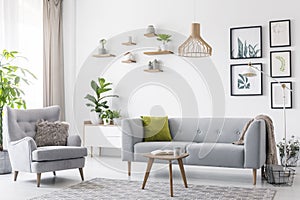 Creative, wooden pendant light above a gray sofa and a comfy arm