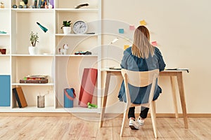 Creative workplace. Young woman in casual clothes sitting at office desk, working or studying at home office. Working