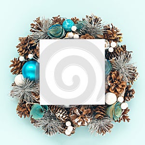 Creative wreath of Christmas decorations, balls and cones with paper card note.