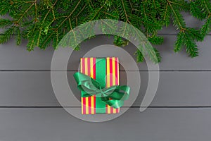 Creative xmas gift box in striped paper, ribbon on desk background