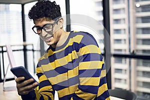 Creative young man looking job on smart phone on desk in the offices.